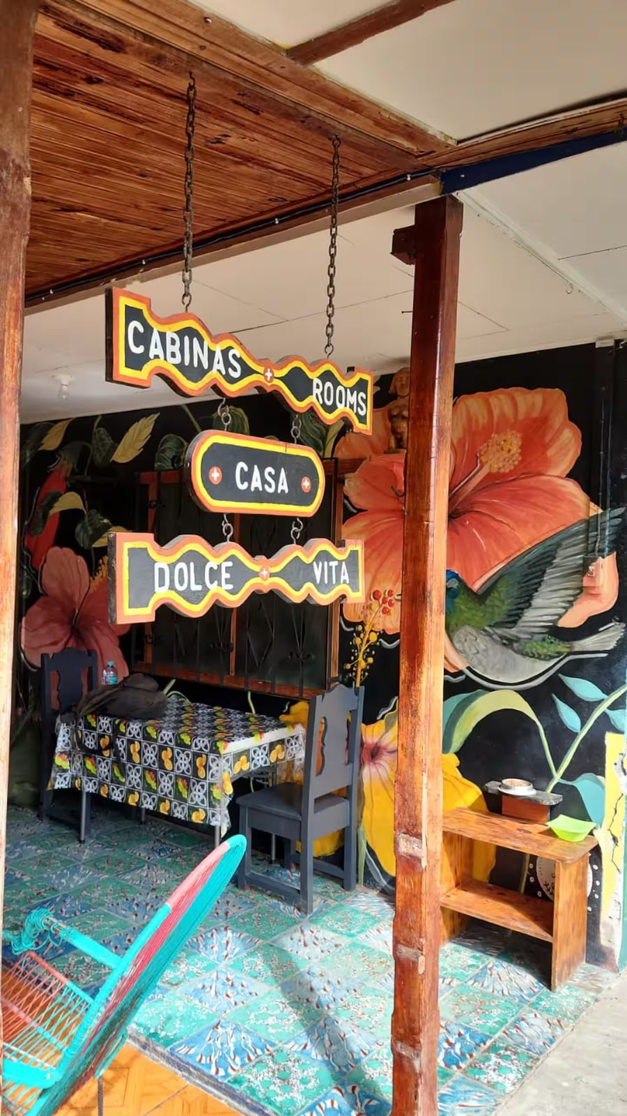 Rótulo de Cabinas Casa Dolce Vita frente a un mural de flores